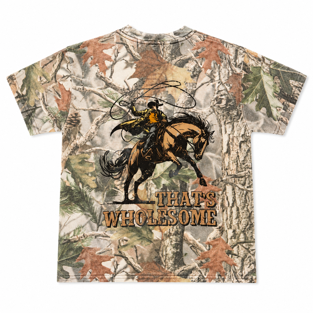 Camouflage t-shirt with a graphic of a cowboy riding a bucking horse and 'THAT'S WHOLESOME' text on a white background.