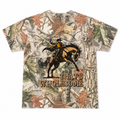 Camouflage t-shirt with a graphic of a cowboy riding a bucking horse and 'THAT'S WHOLESOME' text on a white background.