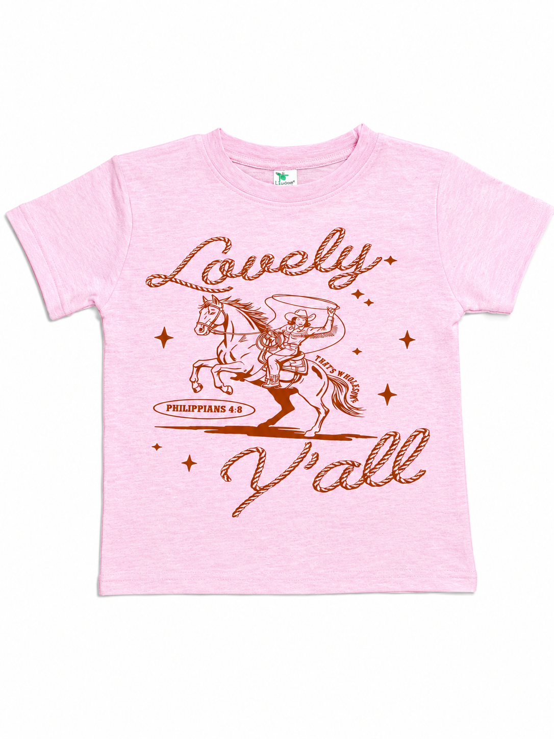 Pink toddler t-shirt flat lay with a rust-colored graphic of a cowboy on a rearing horse, the script text "Lovely" and "Y'all," and "Philippians 4:8" beneath the horse.